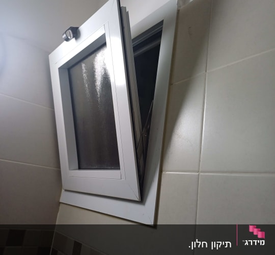 חלון אלומיניום פתוח עם מסגרת לבנה